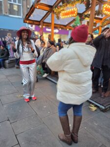 Two women dance in the street to a steel band - RASPO Calypso & Carols 2025 image by Julia Brazil